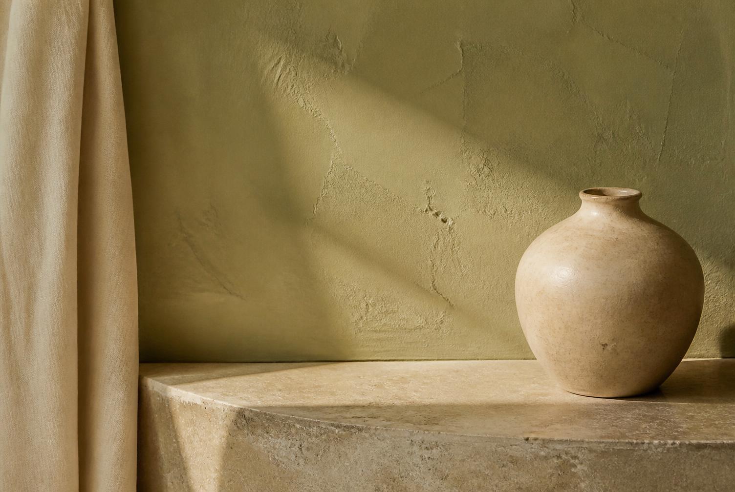 Plaster wall meeting a honed stone ledge